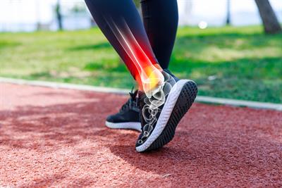 Runner on a track showing pain in the ankle joint